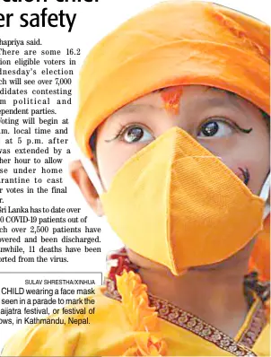  ?? SULAV SHRESTHA/XINHUA ?? A CHILD wearing a face mask is seen in a parade to mark the Gaijatra festival, or festival of cows, in Kathmandu, Nepal.