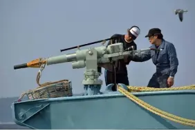  ??  ?? File photo taken on April 25, 2014 crew members of a whaling ship check a whaling gun or harpoon before departure at Ayukawa port in Ishinomaki City