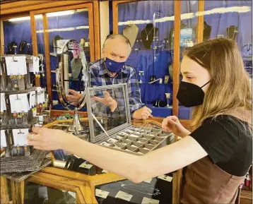  ?? Sarah Kyrcz / Hearst Connecticu­t Media ?? Above, Eva Solarski arranges her earrings at Vera Wolf jewelry store in Guilford as co-owner Wolf Guibbory looks on. Below, some of the earrings, which bear Ukraine’s national colors, on display.