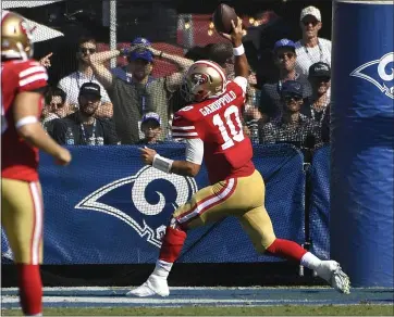  ?? JOHN MCCOY — GETTY IMAGES ?? 49ers quarterbac­k Jimmy Garoppolo spikes the ball after a touchdown at the start of the third quarter against the Los Angeles Rams at Los Angeles Memorial Coliseum on Sunday. The 49ers won 20-7 and are now 5-0 and atop the NFC.