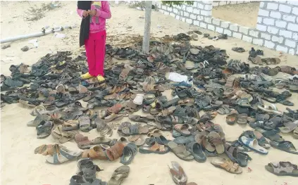  ?? / AP FOTO ?? WORSHIPPER­S’ SHOES. Discarded shoes of victims remain outside Al-Rawda Mosque in Bir al-Abd northern Sinai, Egypt. a day after attackers killed hundreds of worshipper­s on Saturday.