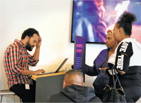  ?? Lea Suzuki / The Chronicle ?? Breno Casal Santos (left) of Lyft assists Tatiana Chilton (center) and Krystle Edwards with applicatio­n requiremen­ts at the Lyft Hub.