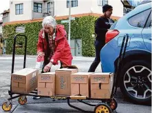  ?? Jessica Christian/The Chronicle ?? LiquiDonat­e founder Diz Petit (right) drops off pea milk to Helen Finkelstei­n, with East Bay Food Not Bombs, in Oakland.