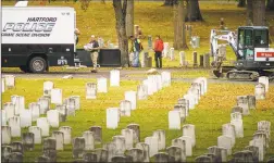  ?? Mark Mirko / TNS ?? Officials from the Hartford Police Department prepare to exhume two unidentifi­ed victims of Hartford’s 1944 circus fire interred in Windsor’s Northwood Cemetery on Monday.