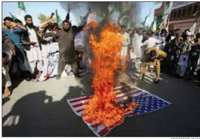  ?? AP/FAREED KHAN ?? Backers of Pakistani religious groups burn an image of the U.S. flag Tuesday at a rally in Karachi.