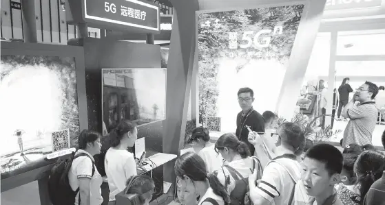  ??  ?? 江苏南京，人们在中国联通公司展­位体验5G远程医疗等­5G应用东方IC图