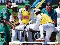  ?? AFP ?? Bangladesh’s Mushfiqur Rahim lifted on to a stretcher by ambulance staff and teammates after being hit in the head.