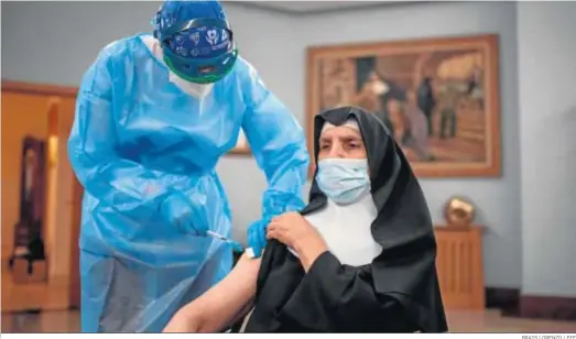  ?? BRAIS LORENZO / EFE ?? Una sanitaria vacuna ayer contra el coronaviru­s a una monja en la residencia San José de Orense.