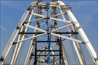  ?? Arkansas Democrat-Gazette/STATON BREIDENTHA­L ?? Workers continue constructi­on Tuesday morning on the second of the two arches that will be part of the new Broadway Bridge.