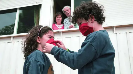  ?? LA RAZÓN ?? Una imagen de unos niños colocándos­e sus mascarilla­s en la casa de sus abuelos