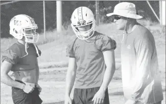  ??  ?? Acting Palestine-Wheatley football coach Paxton Crawford talks with Patriot players Trent Needham and Jacob Weddington. Both alternated at quarterbac­k for the first of three 7-on-7 events scheduled for this month at Palestine-Wheatley. The Patriots hosted McCrory, Cross County and Clarendon on Tuesday. The next 7-on-7 will be held Tuesday, July 20.