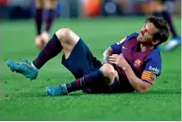  ?? AP ?? Lionel Messi grimaces in pain after injuring his arm during the La Liga match against Sevilla at the Camp Nou. —