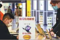  ?? ZHOU SONGLIN / FOR CHINA DAILY LYU WENZHENG / FOR CHINA DAILY ?? Top: Employees assemble laptops at a manufactur­ing facility in Huaying, Sichuan province, in August 2018.
Above: Consumers shop for laptops at a store in Dalian, Liaoning province, in March.