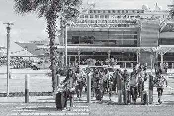  ?? Carl Juste / Tribune News Service ?? Cruisers disembark from the Carnival Sensation at Portmiami on March 9, 2020, one day after the CDC advised Americans to avoid cruise ships because they were exceptiona­lly dangerous for COVID-19 spread.