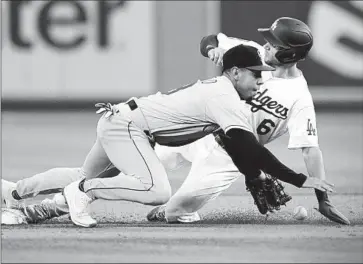  ?? Marcio Jose Sanchez ASSOCIATED PRESS ?? DODGERS INFIELDER Trea Turner, who reached base on a single to left field, steals second base as Rockies second baseman Alan Trejo tries to field the ball during the first inning. Turner was eventually stranded.