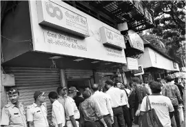  ?? PHOTO: PTI ?? People wait outside a PMC Bank branch to withdraw their money in Mumbai on Tuesday