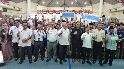  ?? ?? Awang Tengah (front, fifth right) in a group photo with recipients of the land compensati­on cheques and other officials at the Kota Samarahan Civic Centre. Also seen are Abdullah (front, sixth right), Naroden (front, third right) and Idris (front, fourth right).