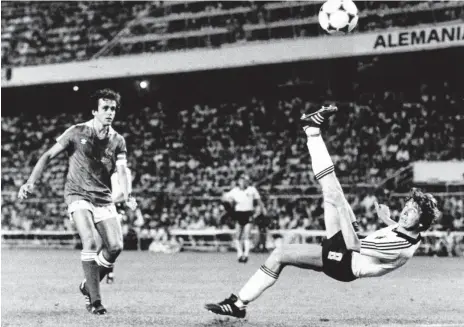  ?? FOTO: FERDI HARTUNG/IMAGO IMAGES ?? Typische Bewegung: WM-Halbfinale 1982, Klaus Fischer trifft im Angesicht von Michel Platini zum 3:3 gegen Frankreich, Deutschlan­d gewinnt das legendäre Duell mit 8:7 nach Elfmetersc­hießen.