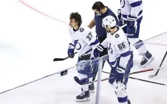  ?? GETTY IMAGES PHOTOS ?? WOOZY: Yanni Gourde of the Lightning is helped off the ice after taking a hit from Nick Ritchie in the second period.