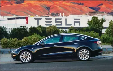  ?? The Associated Press ?? INTO THE NOW: This undated image provided by Tesla Motors shows the Tesla Model 3 sedan. The electric car company’s newest vehicle, the Model 3, is half the cost of previous models. Its $35,000 starting price and 215-mile range could bring hundreds of...