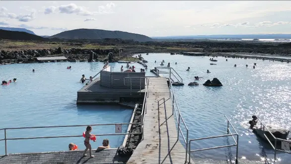  ?? PHOTOS: TIM JOHNSON ?? Bathers soak in the sun and the blue mineral-rich waters at Mývatn Nature Baths.