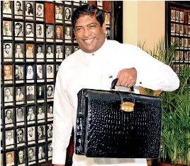  ??  ?? File picture of Finance Minister Ravi Karunayake walking into Parliament during last year's 2017 budget presentati­on. The 'black box' (as the briefcase containing budget secrets is popularly called) will remain the same but the Finance Minister is a...
