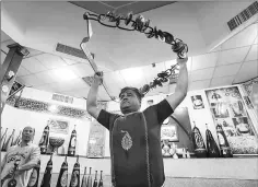  ??  ?? An Iranian trains with a metal bow and chain during a workout session at the traditiona­l Shir Afkan “zurkhaneh” (House of Strength) gymnasium.