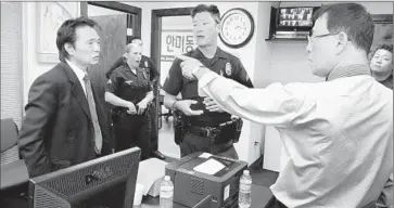 ?? The Korea Times Los Angeles ?? SUNG HOON YOON, left, and Sung Woong Kim argue in the off ices of the Korean American United Foundation. Each claims to be the head of the foundation, which controls the Korean American Community Center.