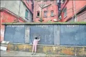  ?? PTI FILE ?? A girl writes an Independen­ce Day greeting on a wallboard at Bow Barrack in central Kolkata on Saturday.