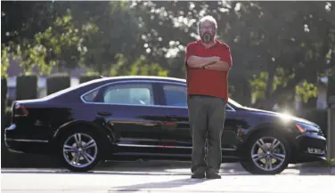  ?? Chris Carlson / Associated Press ?? Bob Rand stands with his 2014, fully loaded Volkswagen diesel Passat — but he doesn’t want to stand by it.