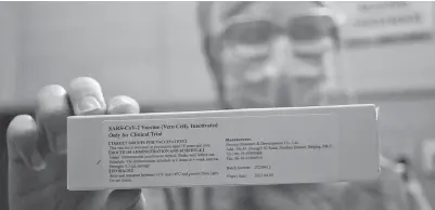  ?? TAOFIK ACHMAD HIDAYAT/RADAR BANDUNG ?? ONLY FOR CLINICAL TRIAL: Petugas kesehatan menunjukka­n contoh kemasan vaksin saat simulasi uji klinis kemarin.