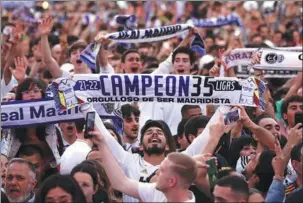  ?? REUTERS ?? Fans celebrate Real Madrid’s La Liga triumph at Cibeles Fountain on Saturday.