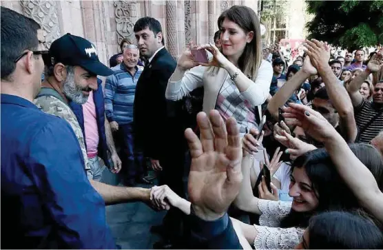  ?? FOTO: GLEB GARANICH / REUTERS ?? Den tidligere journalist­en og opposisjon­slederen Nikol Pasjinjan (t.v.) hylles av tilhengere etter et møte med Jerevan i går. Demonstran­tene vil ha ham som ny statsminis­ter i Armenia.
