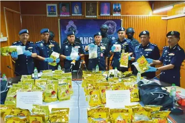  ??  ?? Deadly gold packets: Mohmad Salleh (centre) with Sabah Police Commission­er Datuk Omar Mammah (third from left) displaying the seized syabu during a press conference in Tawau.