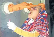  ?? ANI ?? A health worker collects swab sample from a woman at a primary health centre in Gurugram on Monday.