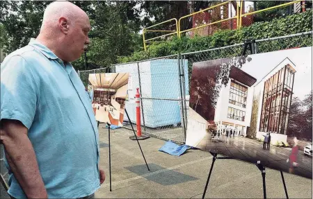  ?? Erik Trautmann / Hearst Connecticu­t Media ?? HMTX Industries employee Rick Taylor looks at a rendering as the company holds a “topping off” reception for its new design headquarte­rs on July 20 on Oakwood Avenue in Norwalk. The building will be the state’s “greenest” commercial building when completed.