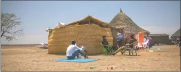  ??  ?? Tigrayan refugees who fled the conflict in Ethiopia’s Tigray try to find a network signal for their mobile phones in Hamdayet.