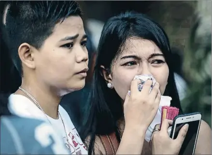  ?? MARK R. CRISTINO / EFE ?? Familiares de las víctimas llorando tras conocer las noticias, ayer en Manila