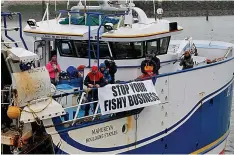  ?? ?? Militant message... French fishermen install a banner on their trawler saying ‘Stop your fishy business’ during the blockade at the port of Calais yesterday