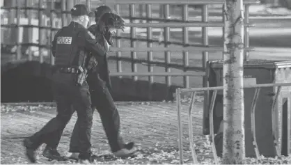  ?? STEVE JOLICOUER VIA REUTERS ?? Police officers detain a man early Sunday morning in an area where multiple people were stabbed near the Parliament Hill area of Quebec City, Que.