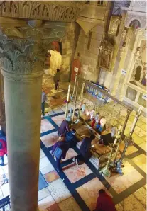  ??  ?? BOW DOWN. Worshipper­s kiss the Stone of Anointing at the main entrance of The Holy Sepulchre Church.