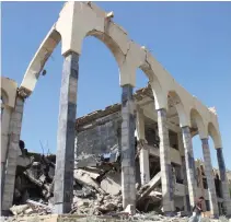  ?? — Reuters – Reuters ?? DESTROYED: A man walks past the headquarte­rs of the court of appeals destroyed by an air strike in Saada, Yemen on Sunday.