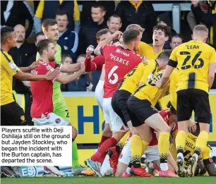  ?? ?? Players scuffle with Deji Oshilaja still on the ground but Jayden Stockley, who began the incident with the Burton captain, has departed the scene.