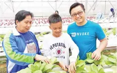  ??  ?? Azizul (right) sharing the concept of hydroponic farming to the visitors in his greenhouse.