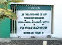  ??  ?? Con una manta, trabajador­es del IMSS exigen la aplicación de la vacuna anti-Covid.