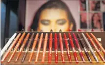  ??  ?? AN IMAGE of a model peers over a row of eyeliner pens at the store, which offers products unavailabl­e elsewhere in the U.S.