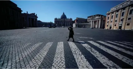  ?? GETTY IMAGES ?? A woman walks across a deserted Pope Pius XII square in Rome near the Vatican’s St. Peter’s Square on Thursday during the lockdown because of the new coronaviru­s pandemic.