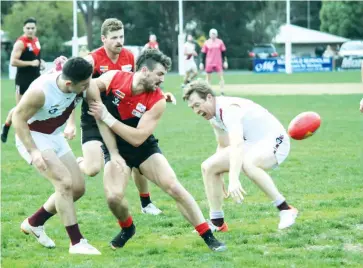  ??  ?? Warragul’s Shaun Beecroft battled two Traralgon opponents, Riley Loprese (left) and Lee Stockdale as the ball spilled free in the senior game at Western Park.