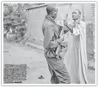  ?? — Gambar AFP ?? GANAS : Seorang lelaki cuba merampas senjata daripada pegawai polis Burundi di perkampung­an Cibitoke, Bujumbura barubaru ini.