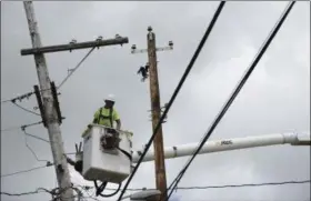  ?? CARLOS GIUSTI — THE ASSOCIATED PRESS ?? A worker with Cobra Energy Company, contracted by the Army Corps of Engineers, installs power lines in Yabucoa, where many people are still without power in Puerto Rico.